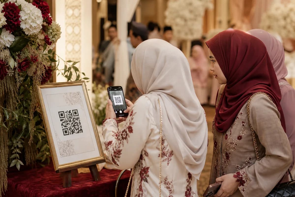 Tetamu bertudung mengimbas kod QR Kenangan pada standee majlis